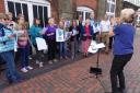The pop-up choir performing outside the Designer Outlet for mental health awareness day.