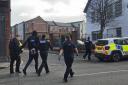 An arrested man is led away by police in Devizes Road today