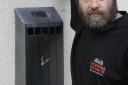 Andy Marcer, landlord of the Beehive pub, beside one of the boxes that has been broken open and the cigarette stubs stolen 