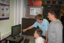 Bradley Laughton from Tregoze Primary with Ashley Laughton being shown the computers by Aaron Stubbs
