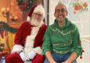 In good company: Councillor Mike Davies sits with Santa at last year's fayre.