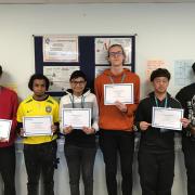 Students at New College with certificates marking their mathematics success