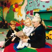 Wendy Ashley tells a story to Luke and Holly Rostill in Debenhams in May 1997 while their mum shops