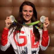 Jazz Carlin shows off her two silver medals after arriving back in the UK