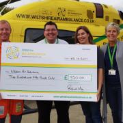 Rob and Meg Faulkner (centre) presenting their donation for the Airbase Appeal to Wiltshire Air Ambulance paramedic Keith Mills (left) and Cas Loudon, donor relationship co-ordinator