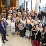 Staff, former staff, and volunteers celebrate the 70th Anniversary at a history centre party.