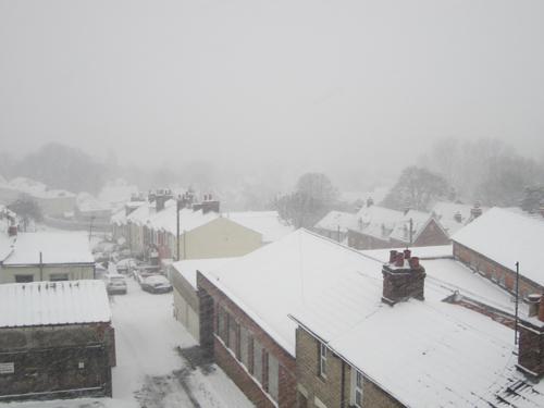 Snow falling across rooftops of Swindon