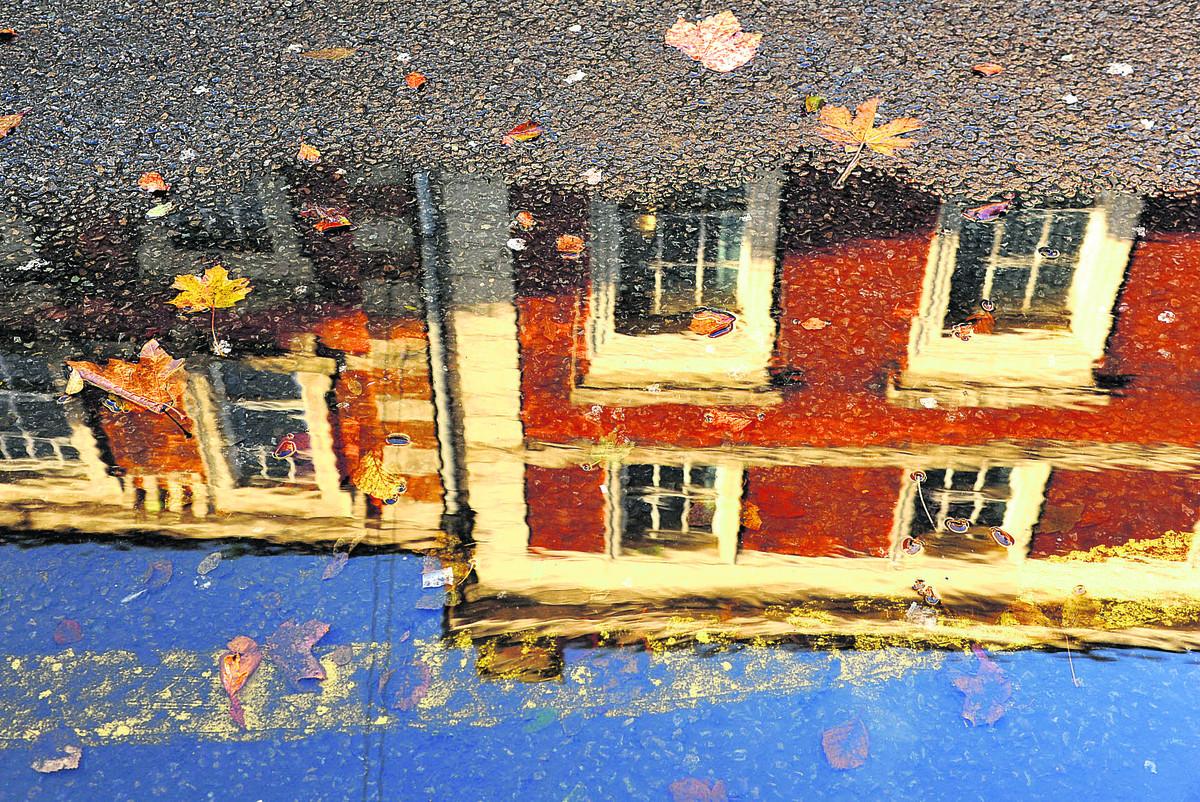  Buildings gleam in a puddle in Wood Street 