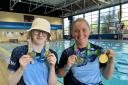 Swindon ASC Para swimmers Suzanna Hext (right) and Ella Williams hold up their respective medals