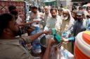 Volunteers provided lime sugar water to people at a camp in Karachi (Fareed Khan/AP)