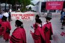 Harvard University students pass protesters while filing into Harvard Yard for commencement on Thursday (Charles Krupa/AP)