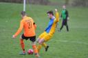 FC Dorcan’s Lewis Freegard (yellow) looks to get the ball away under pressure from Bassett Bulldogs’ Adam Foskett. PICTURE: DAVE COX