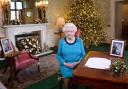 Queen Elizabeth II sitting at a desk in the Regency Room in Buckingham Palace, London, after recording her Christmas Day broadcast to the Commonwealth