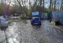 Cars have been forced to wade through the floodwaters up to half a metre deep