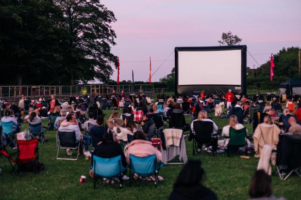 Swindon Advertiser: People at an outdoor cinema event. Credit: Adventure Cinema