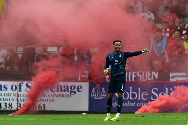 Goalkeeper Jojo Wollacott stands in front of a flare that was thrown onto the pitch by Swindon Town fans at Stevenage earlier this season			  Photo: Rob Noyes