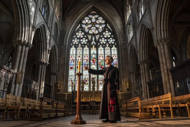 Swindon Advertiser: Very Reverend John Dobson Dean of Ripon lights a candle to mark the second anniversary of the first national coronavirus lockdown at Ripon Cathedral, North Yorkshire, ahead of the National Day of Reflection on Wednesday (PA)