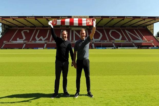 Swindon Town technical director Sandro Di Michele (left) and head coach Scott Lindsey hold up a scarf at Lindsey's unveiling on Monday 			  Photo: Rob Grady
