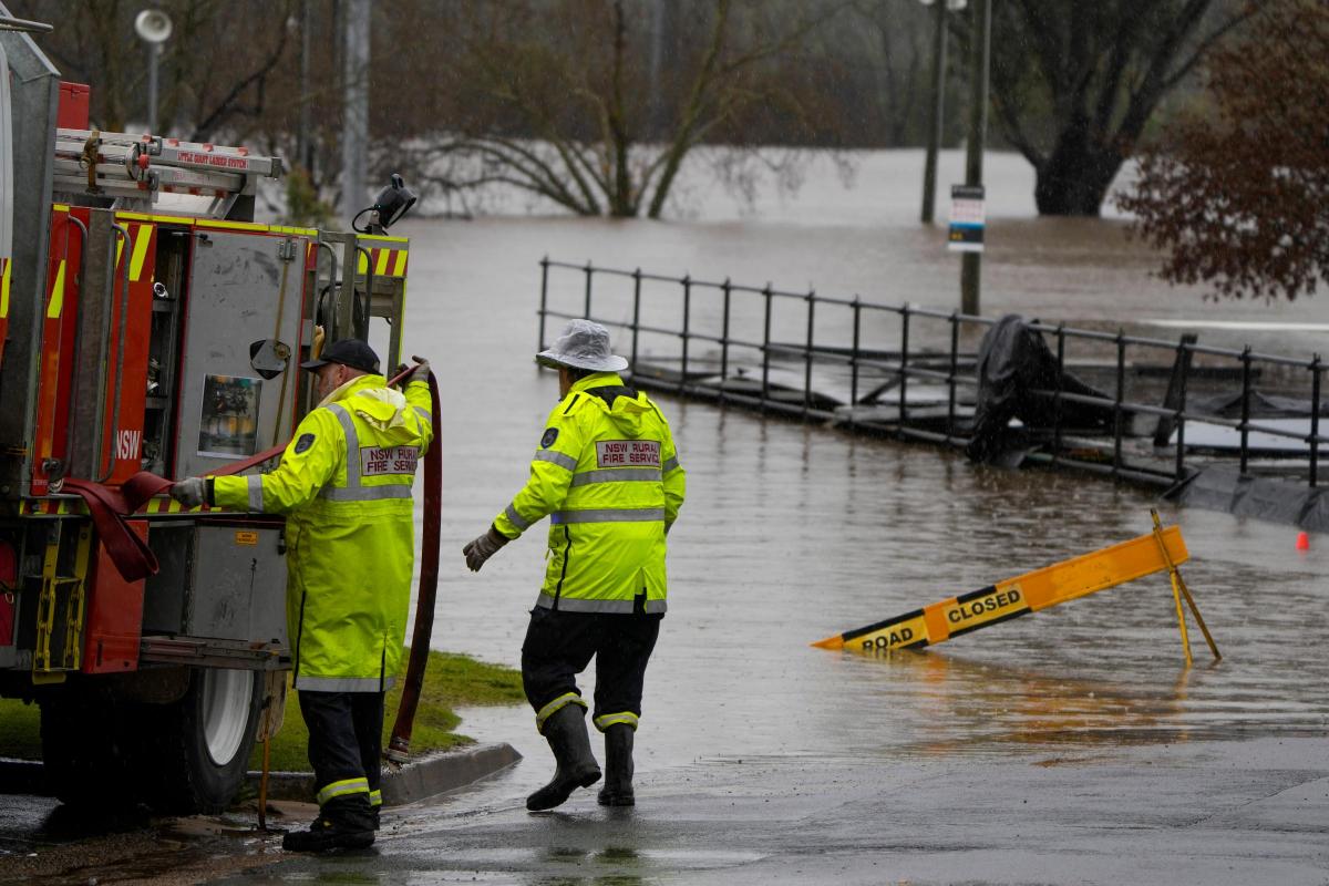 Members of local fire brigade work at a flooded sports venue in Camden on the outskirts of Sydney, Australia