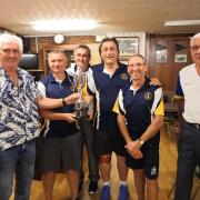 Swindon 2019  Floodlight Tournament winners Westlecot B receive the trophy from left to right: Jim O’Leary (organiser), Kevin Carter (capt), John Thomas, Miles Roberts and Brian Whittingham, plus far right  Bob Hiles (Swindon president) who
