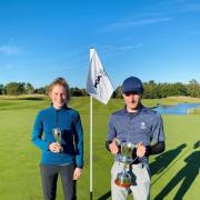 Calum and Maya Fitzgerald holding their respective winner’s trophies at the Bowood Golf Club Championships