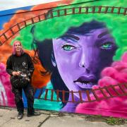 Colourful characters: Sarah Harris stands beside her artistic contribution to Carfax Street.