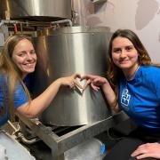 Two of the Swindon Welcomes Ukraine team (Ieva Delininkaityte - left and Yana Shatoka - right) with the batch of beer they are brewing at the Hop Kettle.