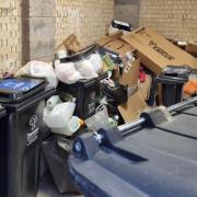 The bin store in the couple's flat building is overflowing.