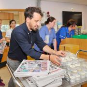 Swindon Advertiser editor Daniel Chipperfield helps hand out cakes and papers on NHS' 75th birthday