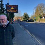 Cllr Jim Grant next to a new digital sign on Kingshill Road