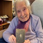 Margaret from Swindon holds a photo of her teenage self who served in the Royal Air Force during the Second World War