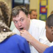 Schools secretary Ed Balls samples chilli potatoes watched by pupils at Drove Primary School