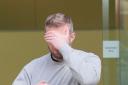 Matthew Trickett covering his face as he leaves Westminster Magistrates’ Court, central London, last week (PA)